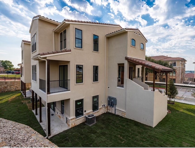 exterior space with a balcony, central AC, and a lawn