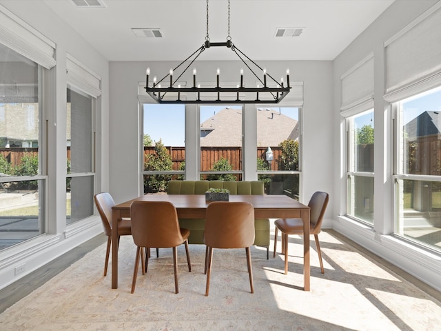 dining area featuring a wealth of natural light, a chandelier, and hardwood / wood-style floors