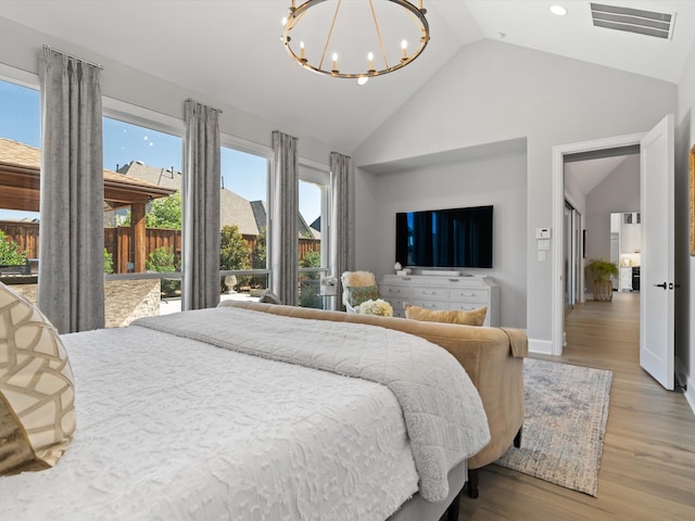 bedroom with high vaulted ceiling, an inviting chandelier, and light wood-type flooring