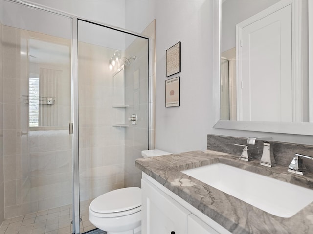 bathroom featuring vanity, an enclosed shower, and toilet