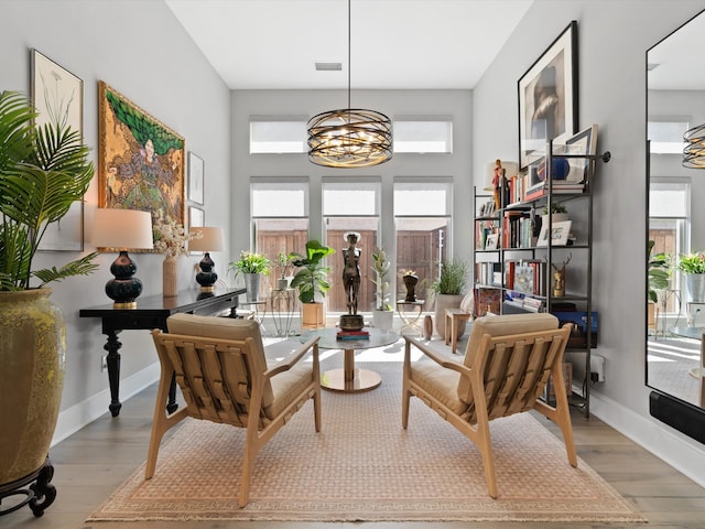 sitting room with light hardwood / wood-style flooring, a notable chandelier, and a wealth of natural light