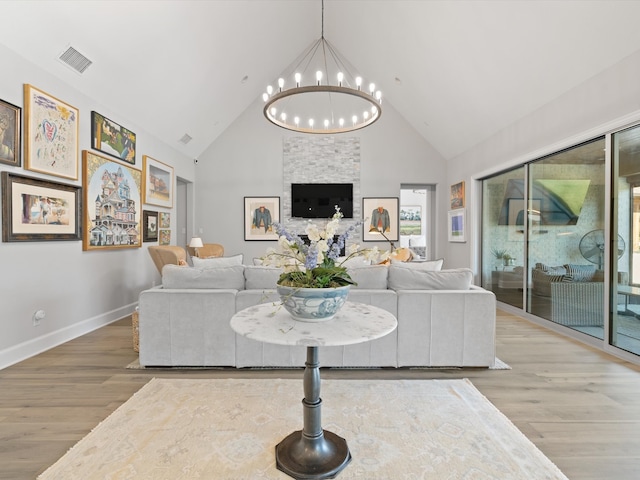 living room featuring high vaulted ceiling, a chandelier, and hardwood / wood-style floors