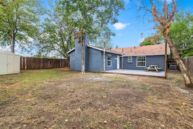 back of property with a patio, a storage unit, and cooling unit