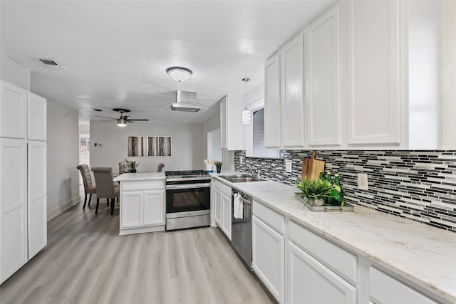 kitchen featuring stainless steel appliances, backsplash, decorative light fixtures, light wood-type flooring, and white cabinets