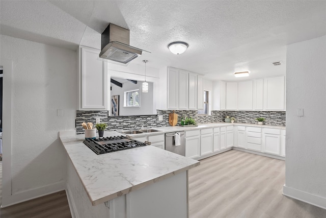 kitchen featuring stainless steel appliances, light hardwood / wood-style flooring, kitchen peninsula, and white cabinets