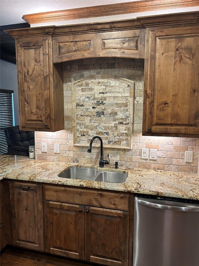 kitchen with stainless steel dishwasher, dark brown cabinets, and sink