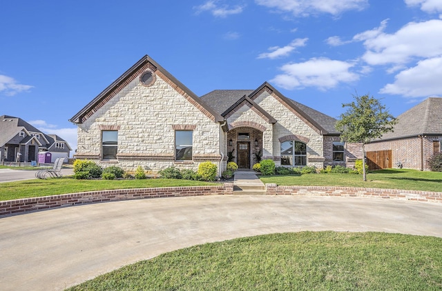 french country inspired facade with a front yard