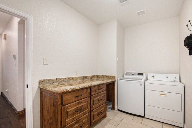 laundry room with washer and clothes dryer and light tile patterned floors