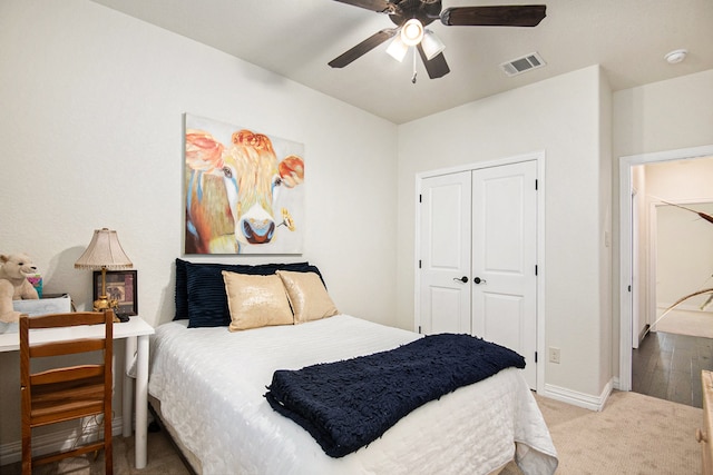 bedroom featuring ceiling fan, light colored carpet, and a closet