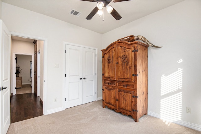 bedroom featuring ceiling fan, a closet, and light colored carpet