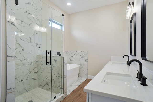 bathroom featuring independent shower and bath, wood-type flooring, and vanity