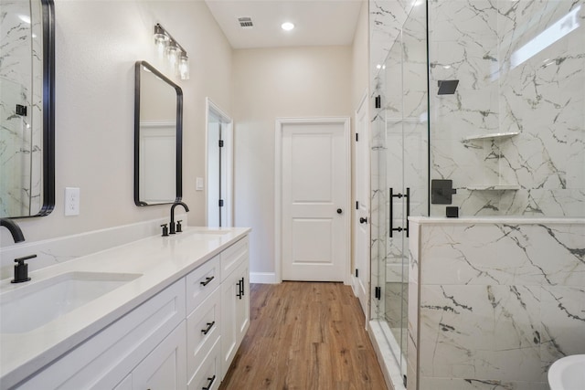 bathroom with vanity, hardwood / wood-style floors, and a shower with shower door