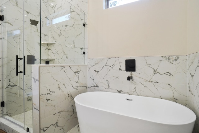 bathroom featuring tile walls and separate shower and tub