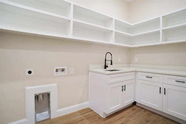 washroom with hookup for a washing machine, cabinets, sink, light hardwood / wood-style floors, and electric dryer hookup