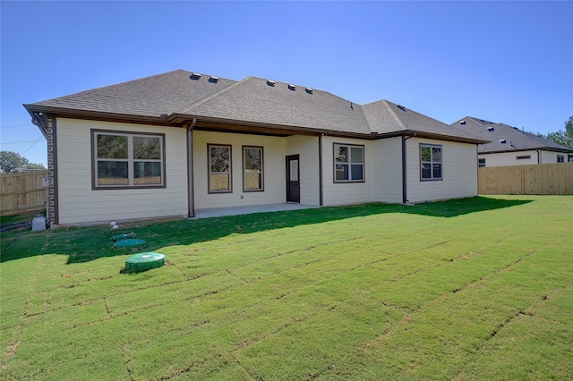 rear view of house featuring a yard