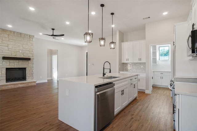 kitchen with white cabinetry, sink, and a kitchen island with sink