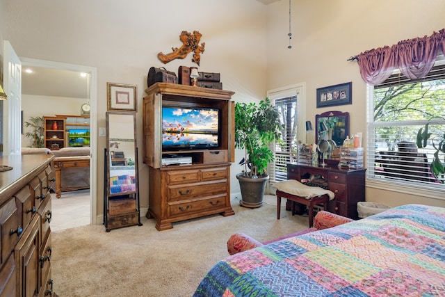 carpeted bedroom featuring a high ceiling