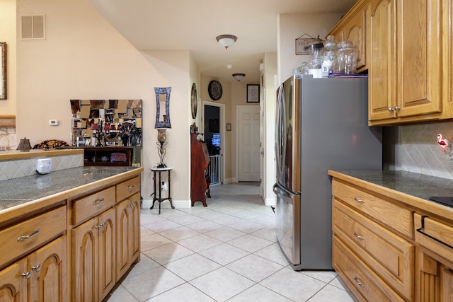 kitchen with tasteful backsplash, stainless steel fridge, and light tile patterned flooring