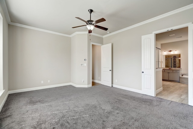 unfurnished bedroom featuring ensuite bath, ornamental molding, light colored carpet, and ceiling fan