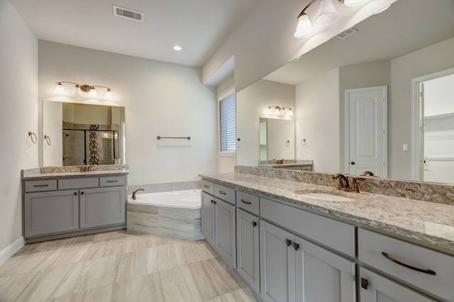 bathroom with vanity and independent shower and bath