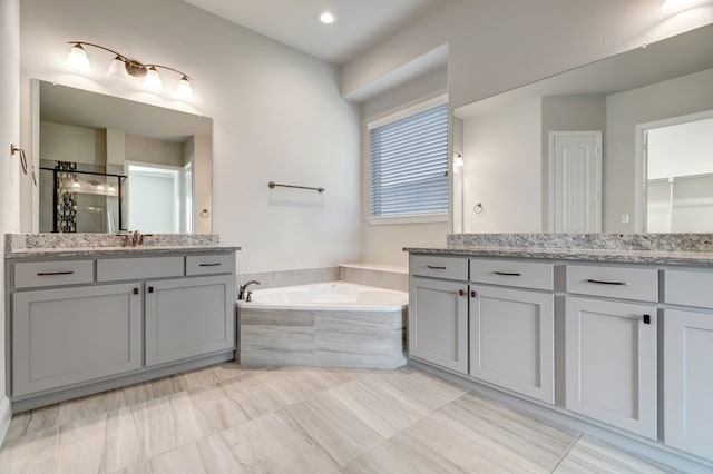 bathroom featuring vanity and tiled tub