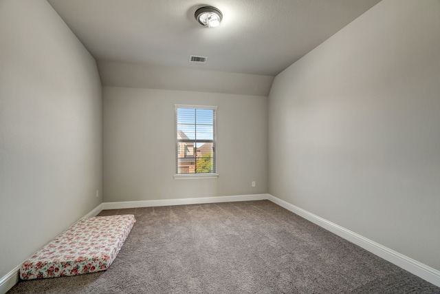 spare room with vaulted ceiling and carpet floors