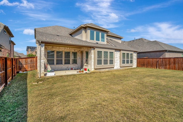 back of house with a patio area and a lawn