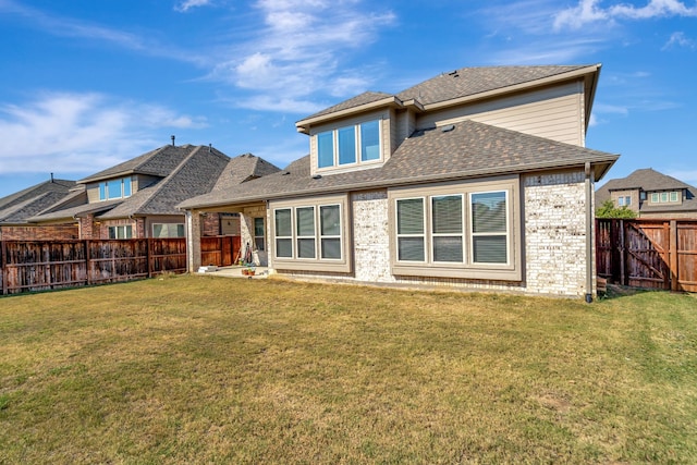 rear view of house featuring a yard