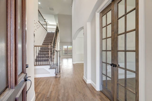 entryway featuring hardwood / wood-style flooring and a towering ceiling