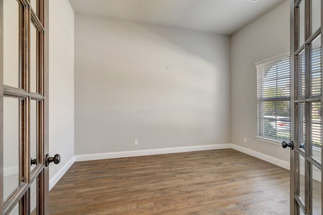 empty room featuring french doors and dark hardwood / wood-style floors