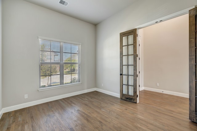 spare room featuring french doors and wood-type flooring