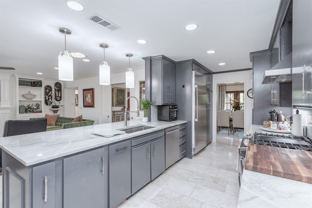 kitchen featuring gray cabinets, sink, and pendant lighting