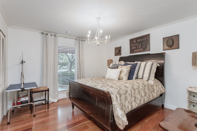 bedroom with hardwood / wood-style flooring, crown molding, and an inviting chandelier