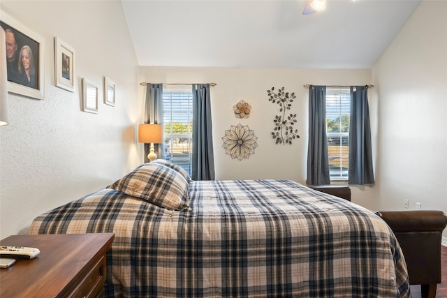 bedroom with ceiling fan, lofted ceiling, and multiple windows