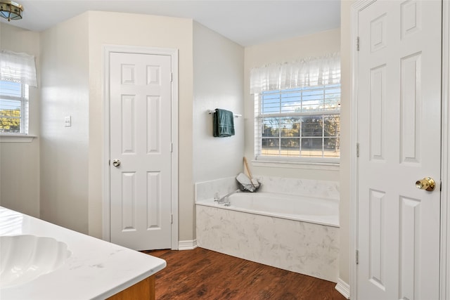 bathroom featuring vanity, a bathtub, hardwood / wood-style floors, and plenty of natural light