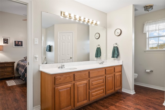 bathroom featuring vanity, hardwood / wood-style flooring, and toilet