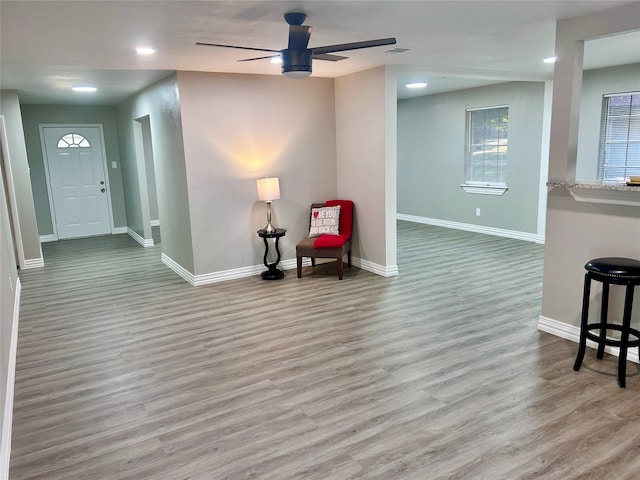 unfurnished living room featuring light hardwood / wood-style floors, sink, a fireplace, and ceiling fan