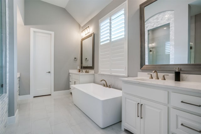 bathroom with a tub to relax in, lofted ceiling, and vanity