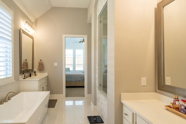 bathroom with vaulted ceiling, vanity, a bathing tub, and tile patterned flooring