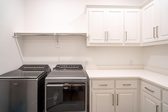 washroom with cabinets and washing machine and dryer