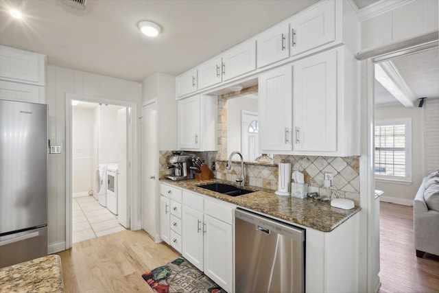 kitchen featuring light hardwood / wood-style floors, stainless steel appliances, sink, and separate washer and dryer