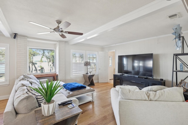 living room featuring beam ceiling, ornamental molding, light wood-type flooring, and ceiling fan