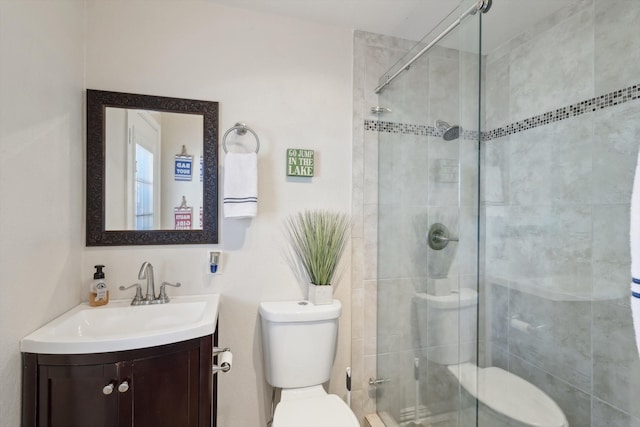 bathroom with toilet, an enclosed shower, and vanity