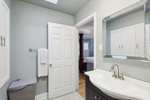 bathroom with vanity, a skylight, and hardwood / wood-style floors