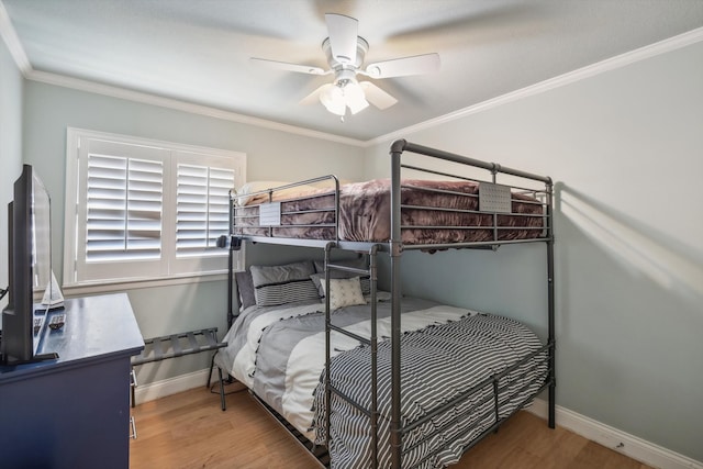 bedroom with ornamental molding, hardwood / wood-style flooring, and ceiling fan