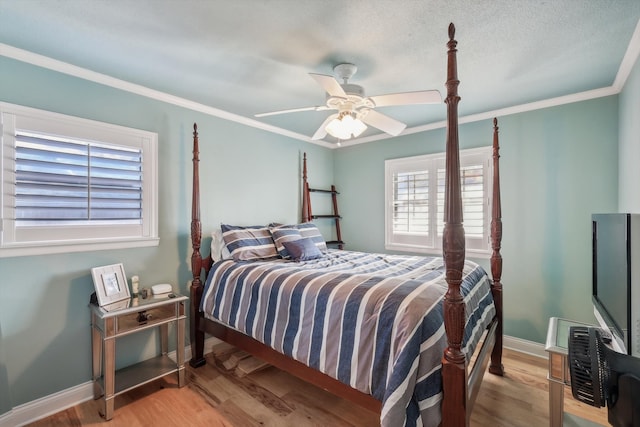 bedroom featuring ceiling fan, ornamental molding, a textured ceiling, and light hardwood / wood-style floors