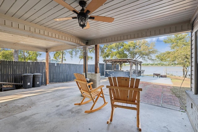 view of patio with a water view and ceiling fan