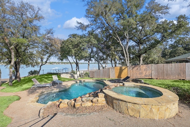 view of swimming pool featuring a water view, an in ground hot tub, a lawn, and a patio area