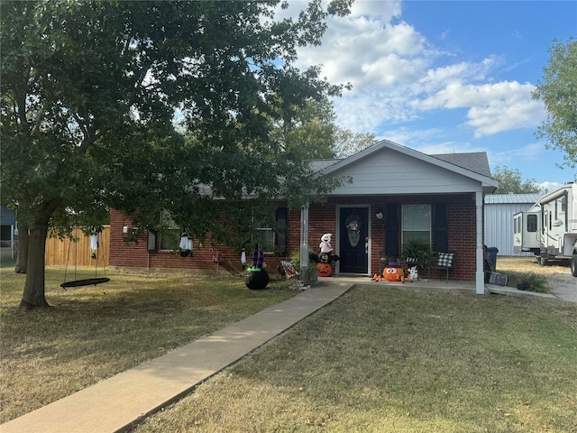105 N 6th St E, Dawson, TX 76639 - view of front of property featuring a front lawn, a porch, and brick siding