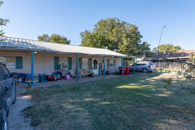 view of front of home featuring covered porch, cooling unit, and a front lawn